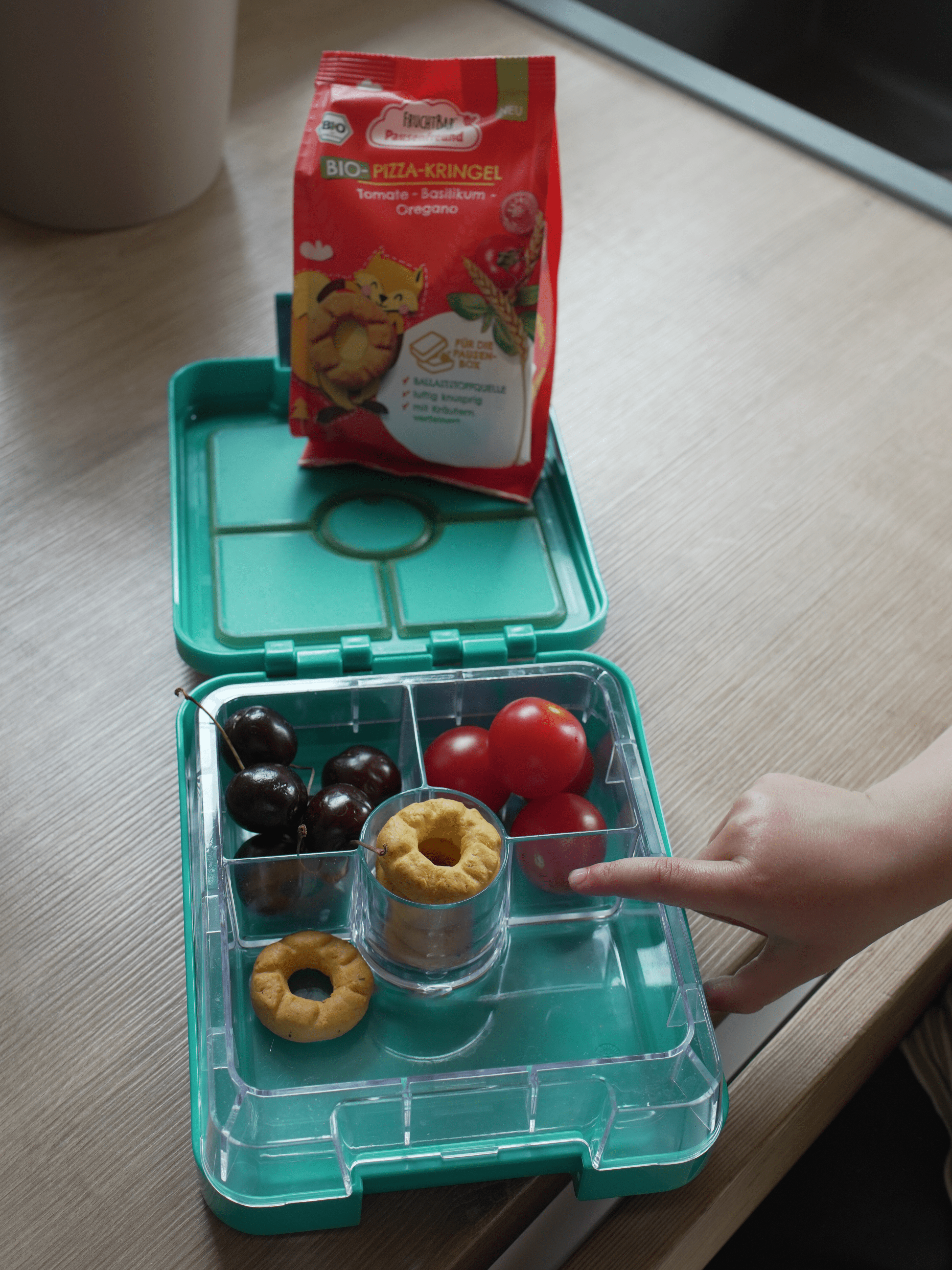 Bio Pizza Kringel in der Brotdose Grüne Botdose mit Kirschen, Tomaten udn Pausenfreund Pizza Kringel