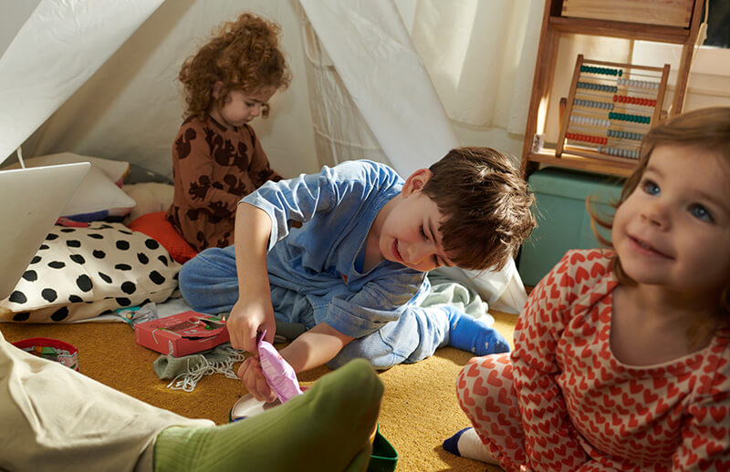 Kinder spielen im Zimmer und essen FruchtBar Riegel